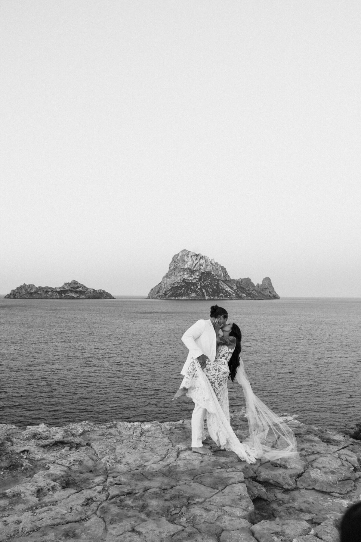Wedding couple doing a dip in front of Es Vedra during a photoshoot
