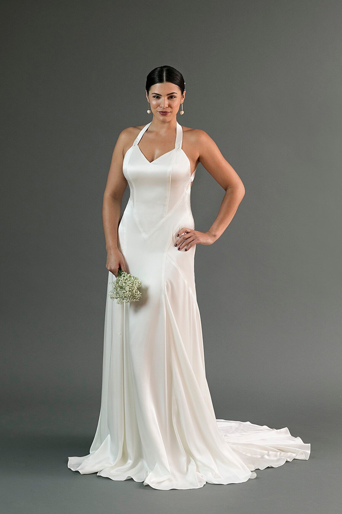 Yuri is a charmeuse wedding dress in a slinky silhouette with a v-neck and intricate seamlines.