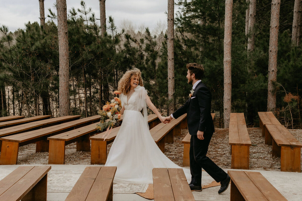 couple-walking-woods-wedding-portrait-pinewood-weddings-and-events-cambridge-minnesota-des-moines-wedding-photographer-storyteller-collective-photo-co