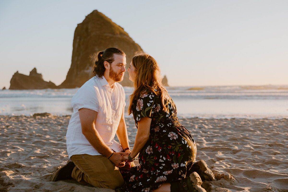 cannon beach engagement during a golden sunset in front of haystack rock at the oregon coast