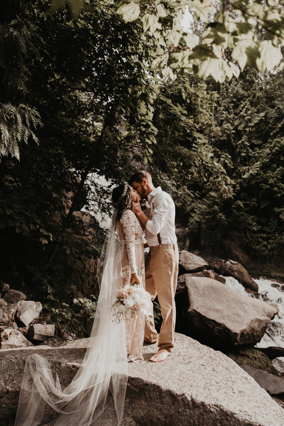 Trendy, boho inspired wedding, bride wearing ivory nude sheer lace gown, groom wearing classic white shirt, tan khakis, and leather suspenders, captured by Kelsey Vera Photography, intimate and romantic wedding photographer in Airdrie, Alberta. Featured on the Bronte Bride Vendor Guide.
