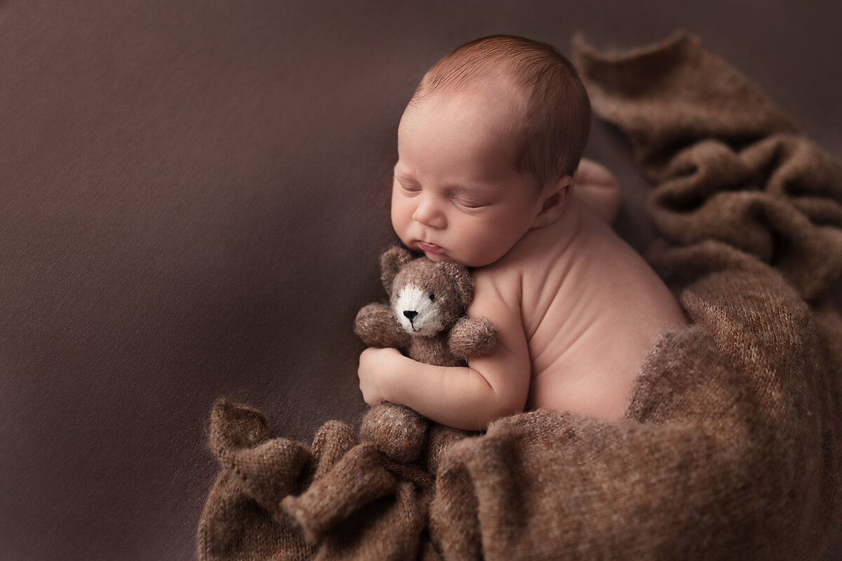 Newborn wrapped in brown holding a tiny teddy — Mississauga newborn photographer