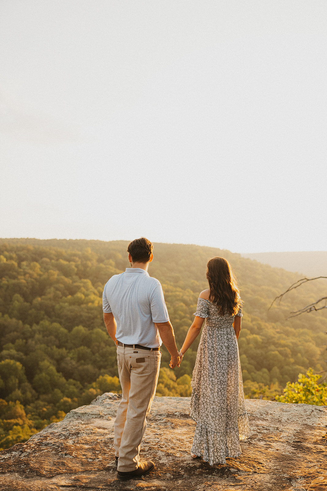 couple holding hands overlooking mountains