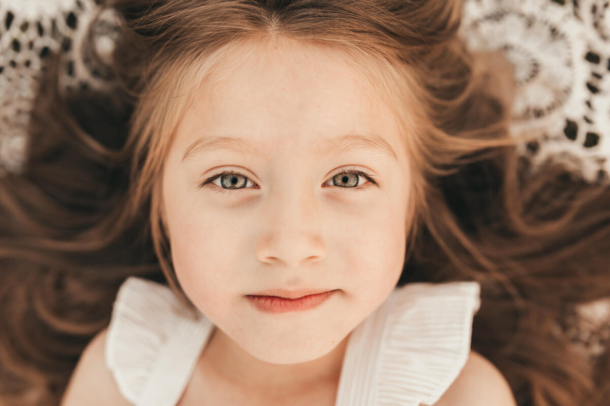 close up of little girl smirking at camera.