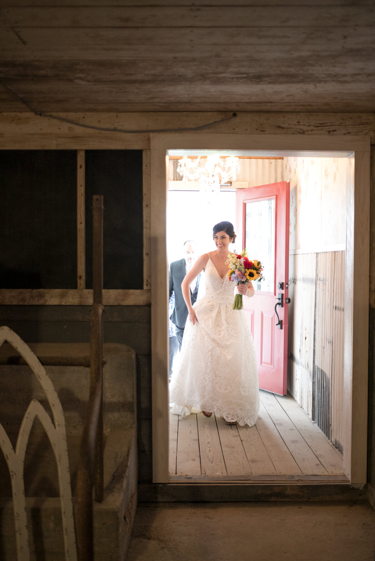 A bride walking through the dairy barn on wedding day