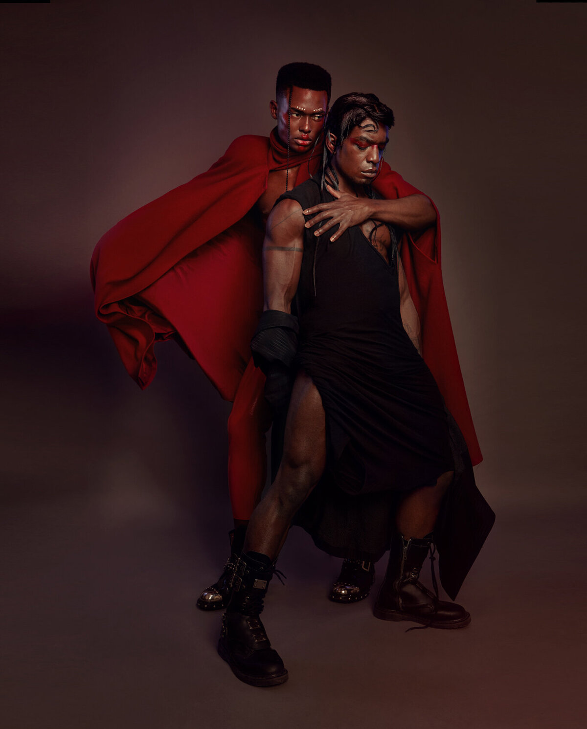 Powerful portrait of Jonzu Julian in a red cape, exuding confidence, captured by Ylva Erevall.