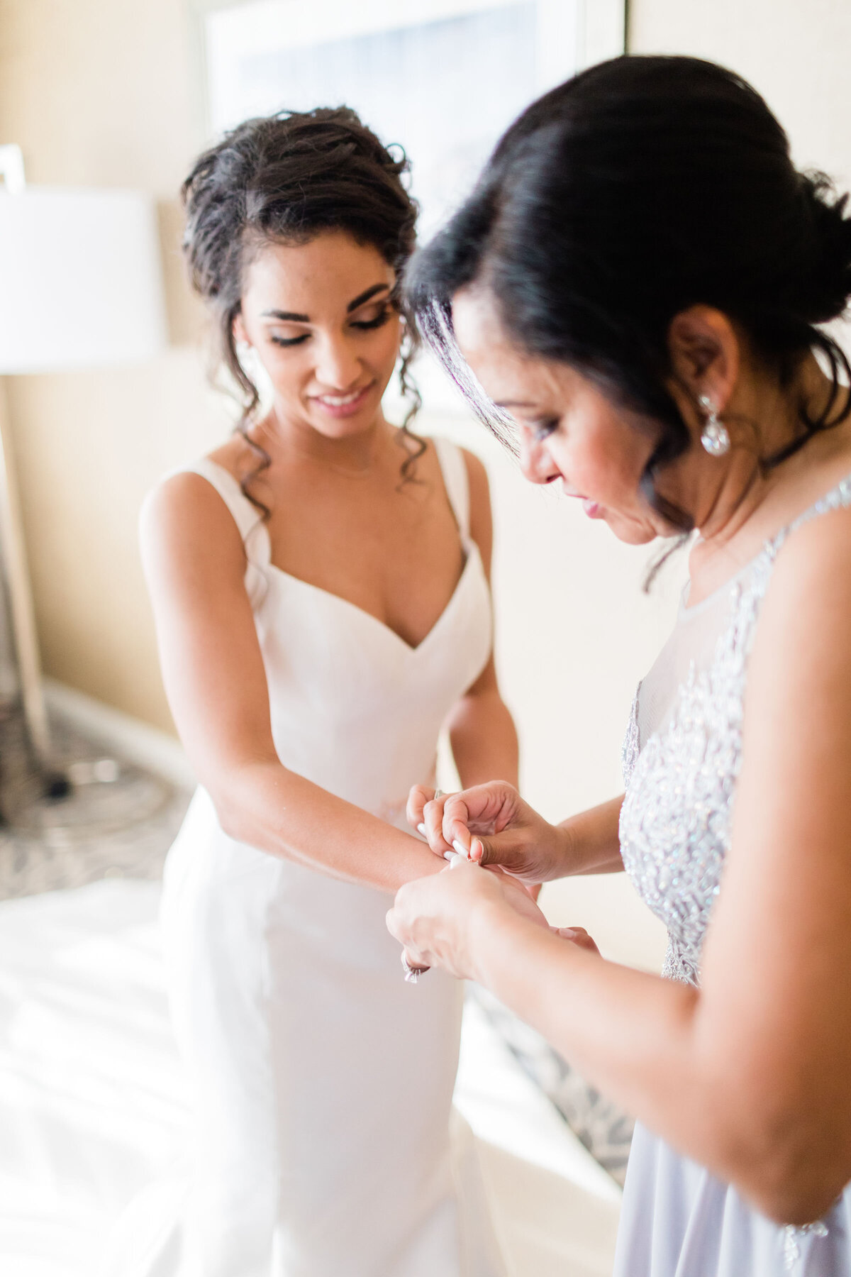 Mom helping bride put on bracelet