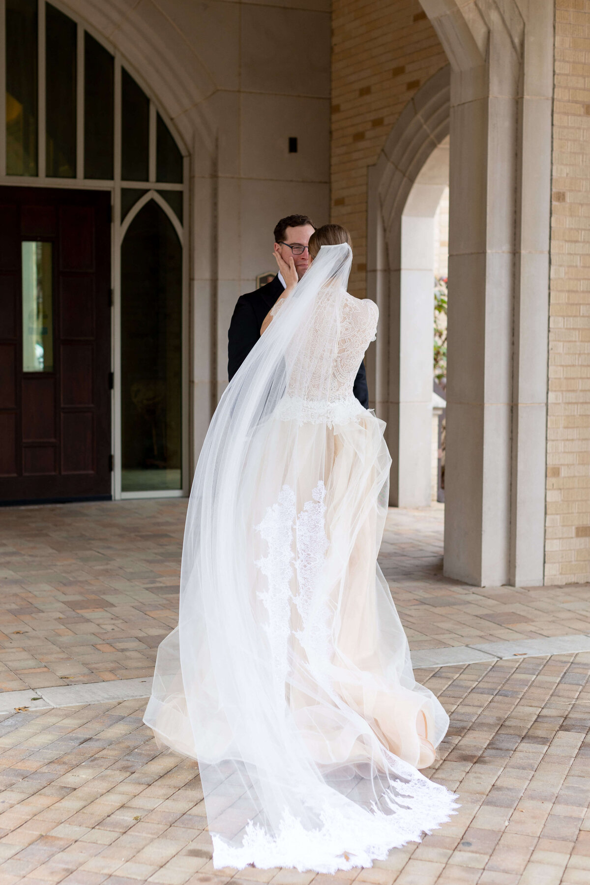 Bride and groom first look in Dallas, with the bride in a lace gown and cathedral veil