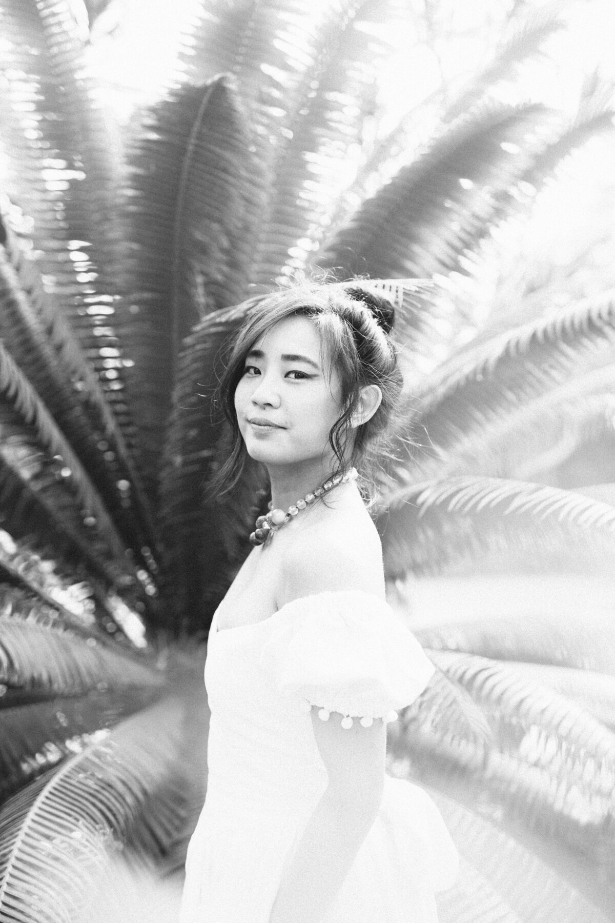 A dramatic and beautiful portrait of the bride on black and white film emphasizing the light and grain in front of the scenic natural setting of Dos Pueblos Orchid Farm.