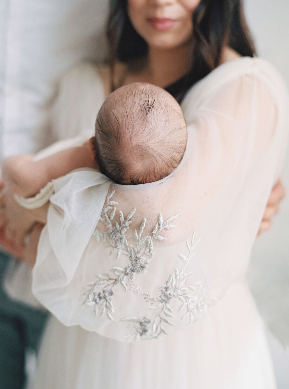 Mother cradling newborn during intimate Bay Area newborn photography session.