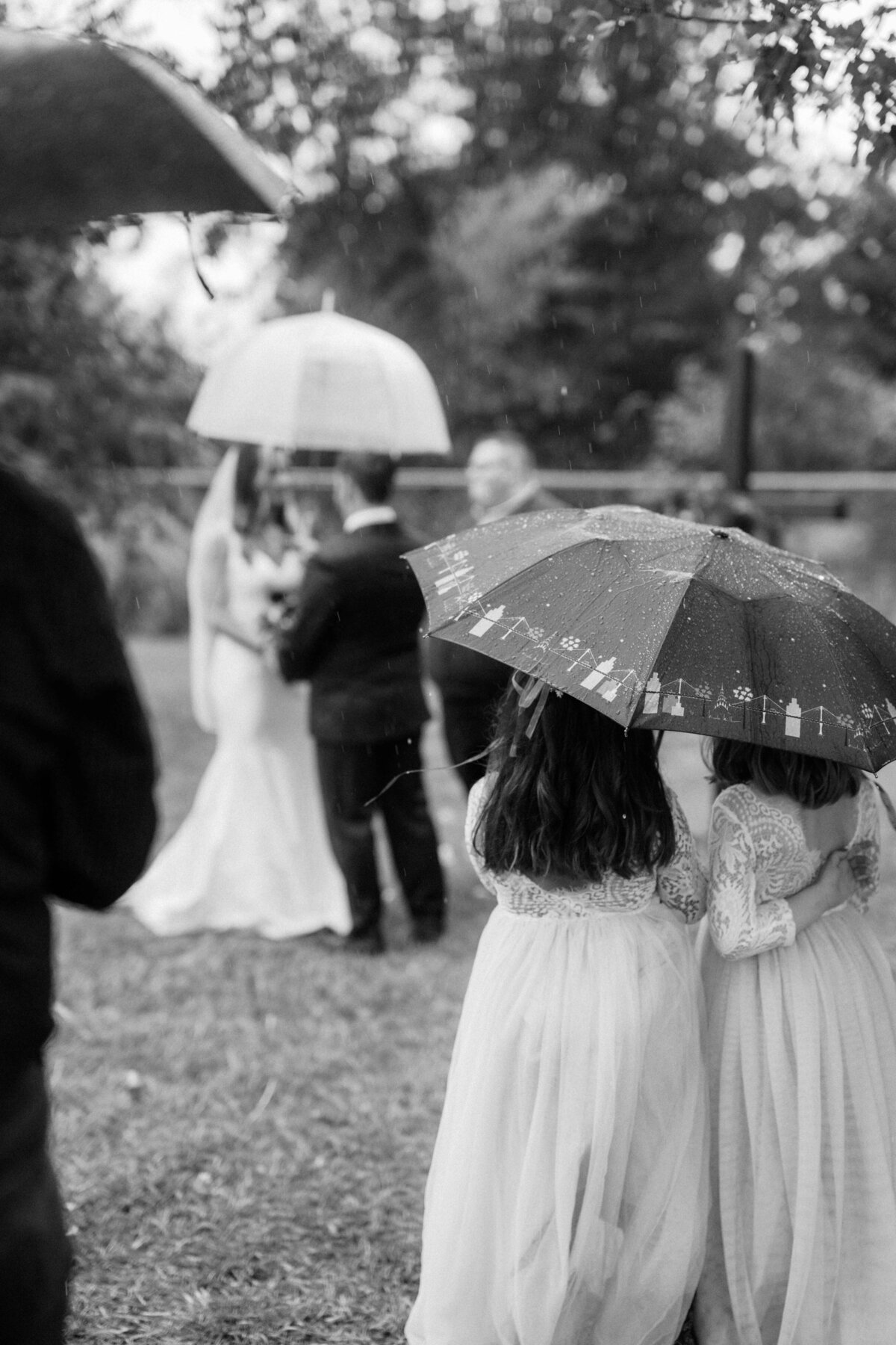 little-girls-under-umbrella-watching-rainy-ceremony