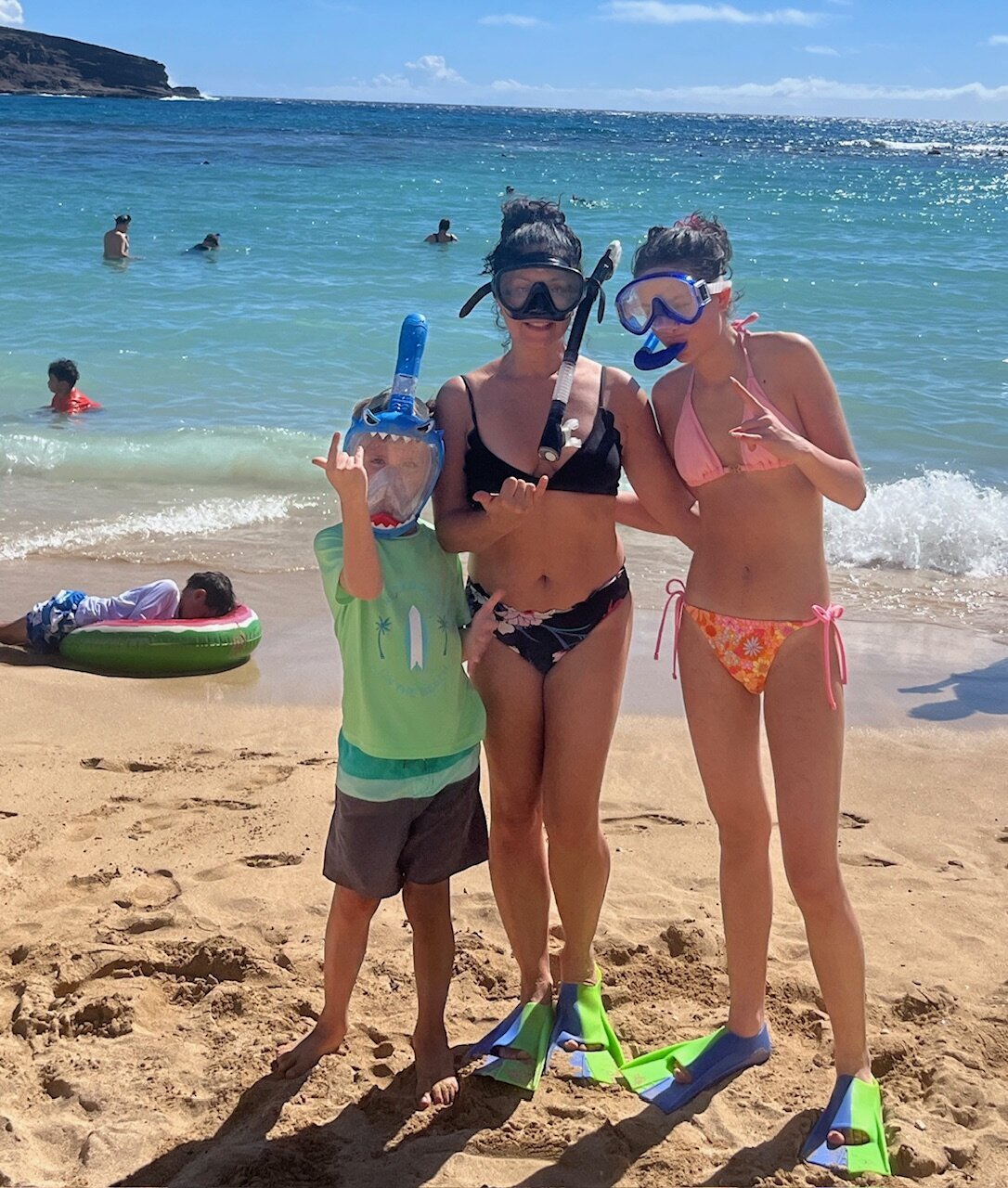 Sonia's family standing on the beach in snorkel gear