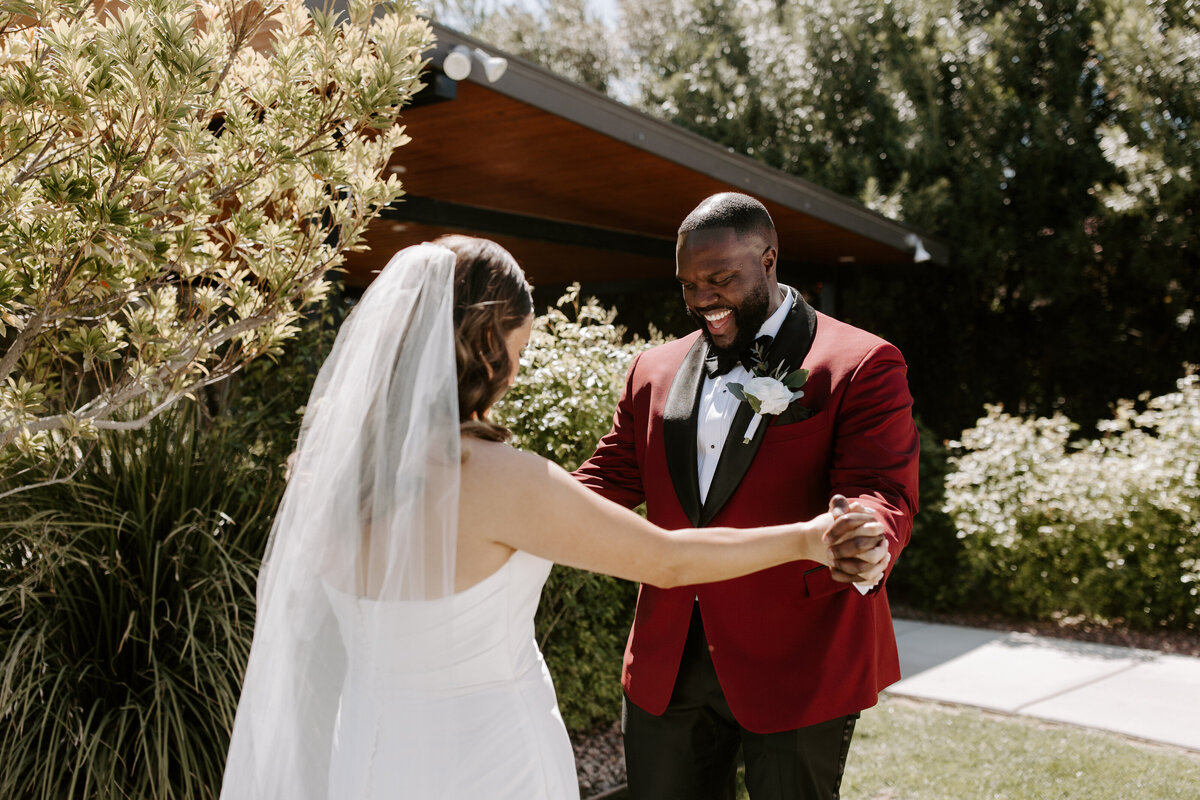 A couple smiles happily during a first look.