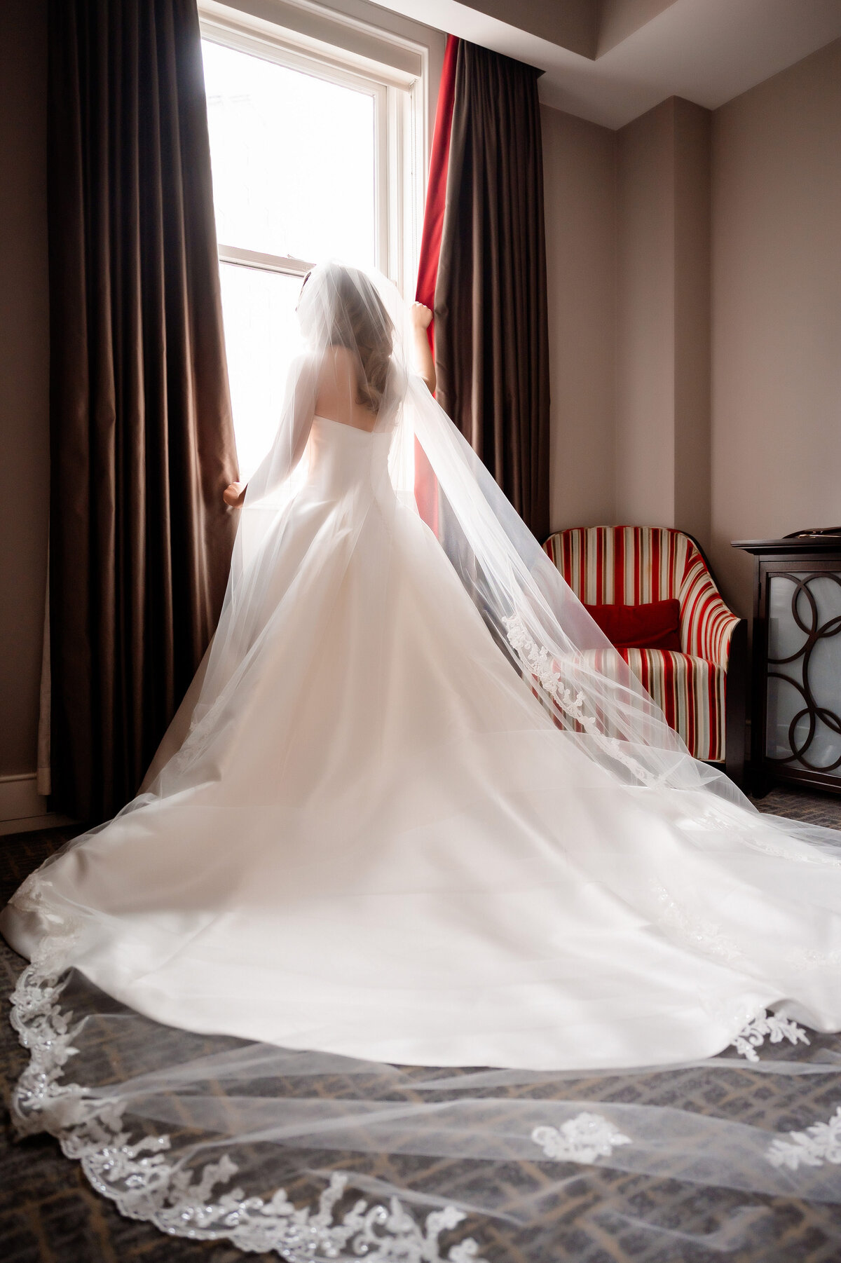 bride in the suite with large wedding dress before her event