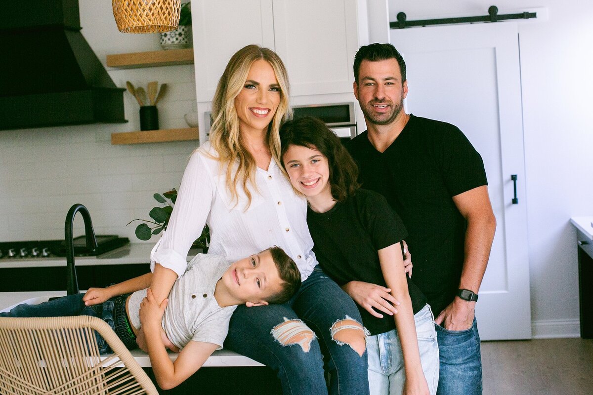 A-modern-family-posing-together-in-a-beautiful-home-in-Brownsburg-Indiana-during-a-lifestyle-photo-session-capturing-candid-family-moments