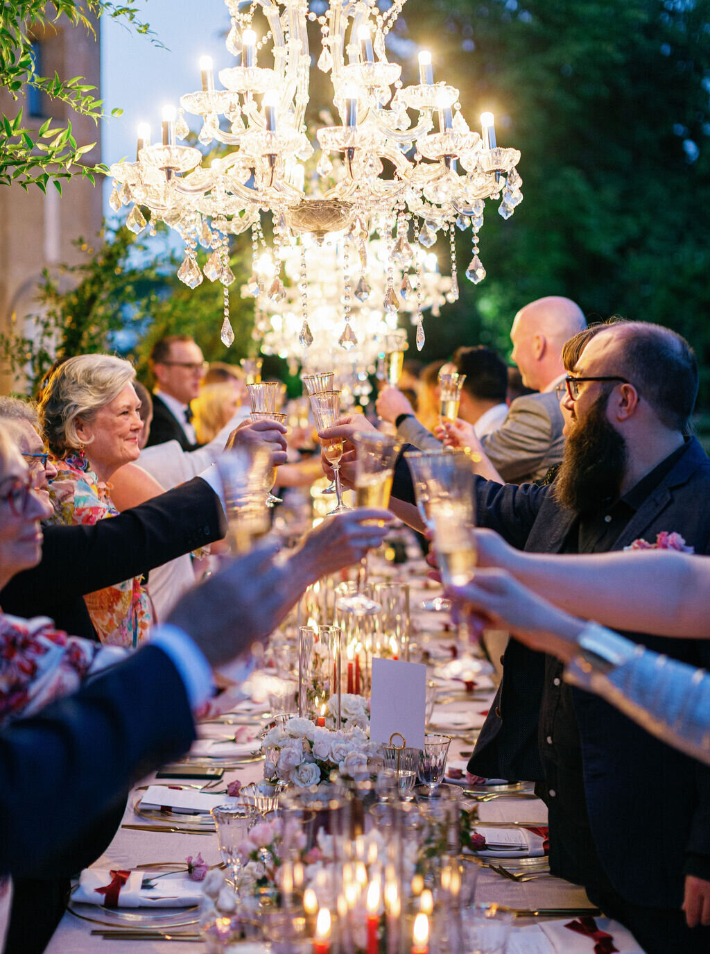 wedding-dinner-table-under-elegant-chandelier-and-flowers