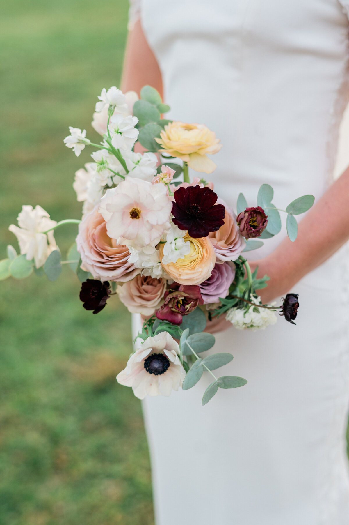 Bride holds bouquet of white and yellow flowers