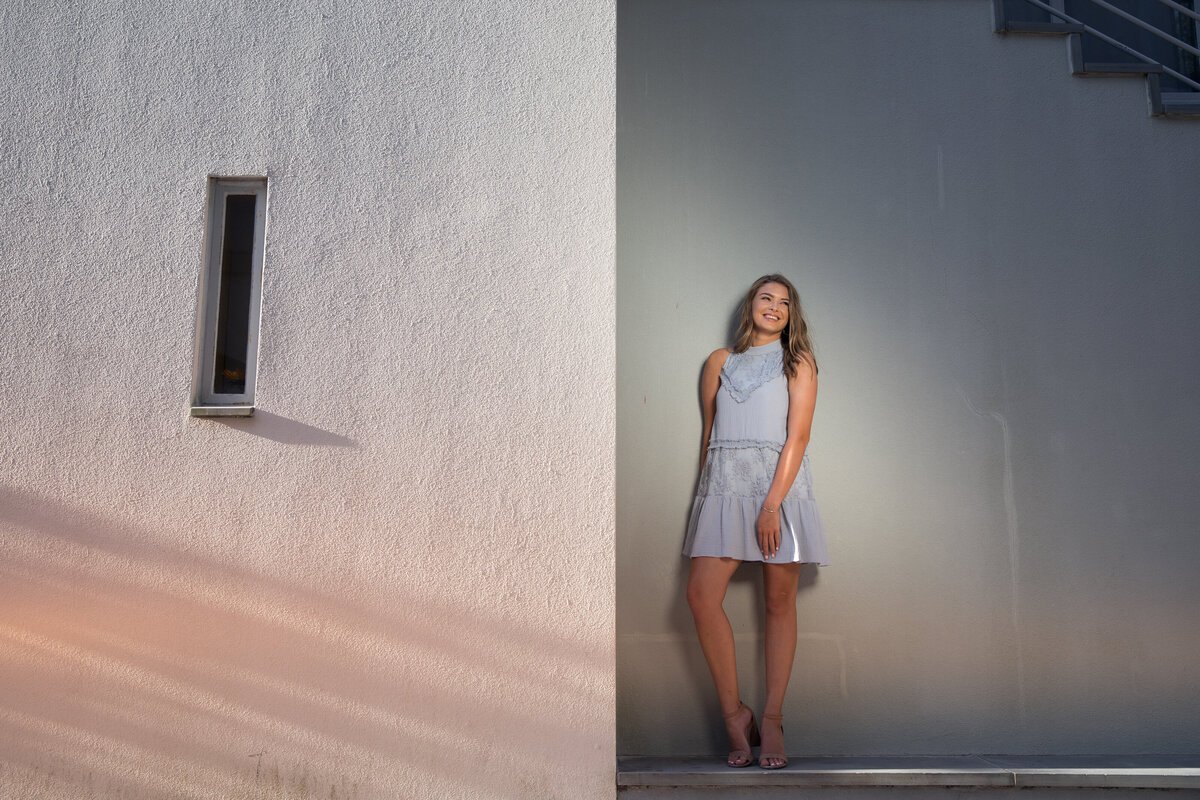 A girl standing at the corner of a building