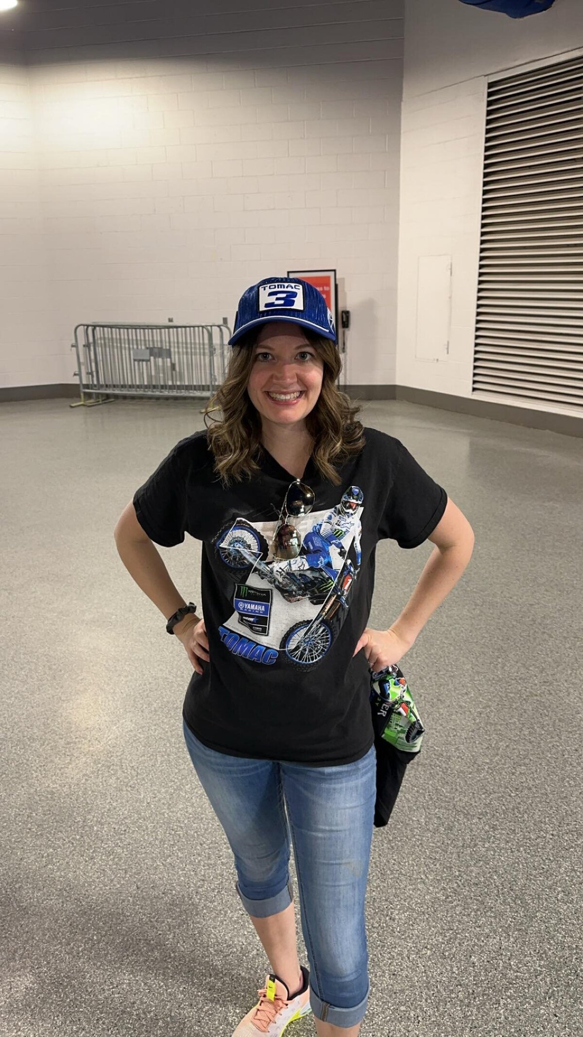 a woman poses hands on hips in t shirt and jeans