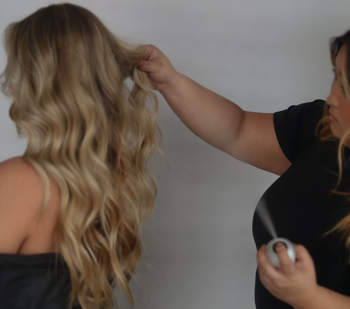 hair stylist styling a woman's hair