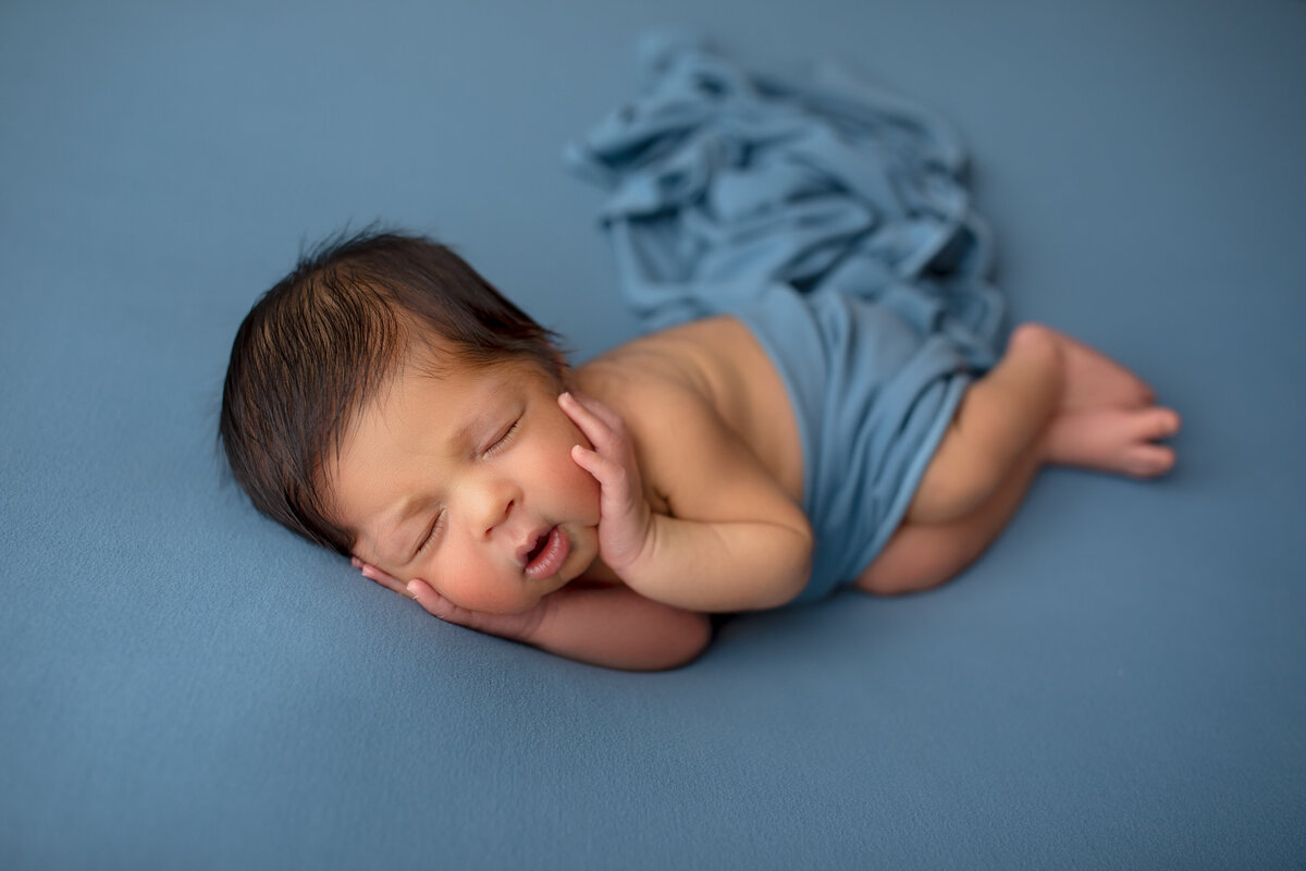A delicate close-up of a sleeping newborn, showcasing their tiny fingers and peaceful expression. Perfectly captured in our Phoenix studio, this image highlights the innocence of your baby’s first days.