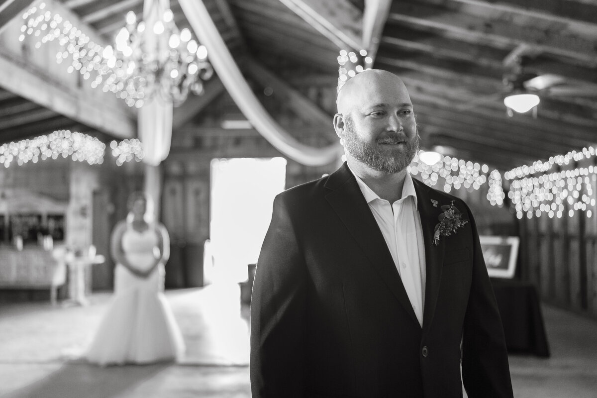 Groom watching bride walk aisle