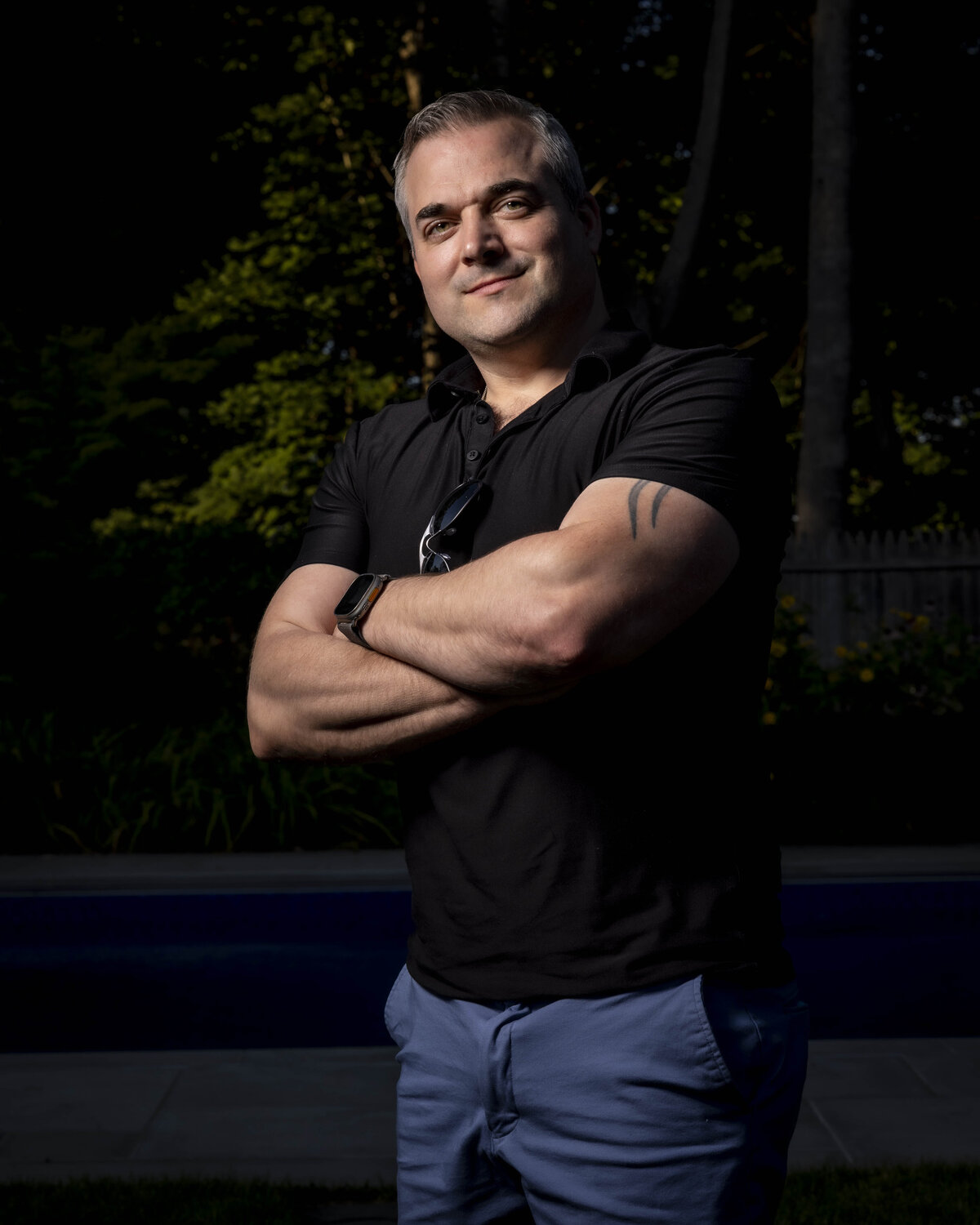 Headshot in CT of man in black t-shirt with arms crossed, photographed outdoors by Rob Faber Photography.