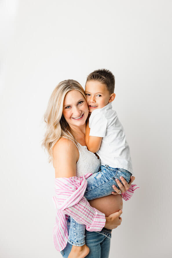 A mom and her son cheek to cheek in the studio at Angela Marie Media.