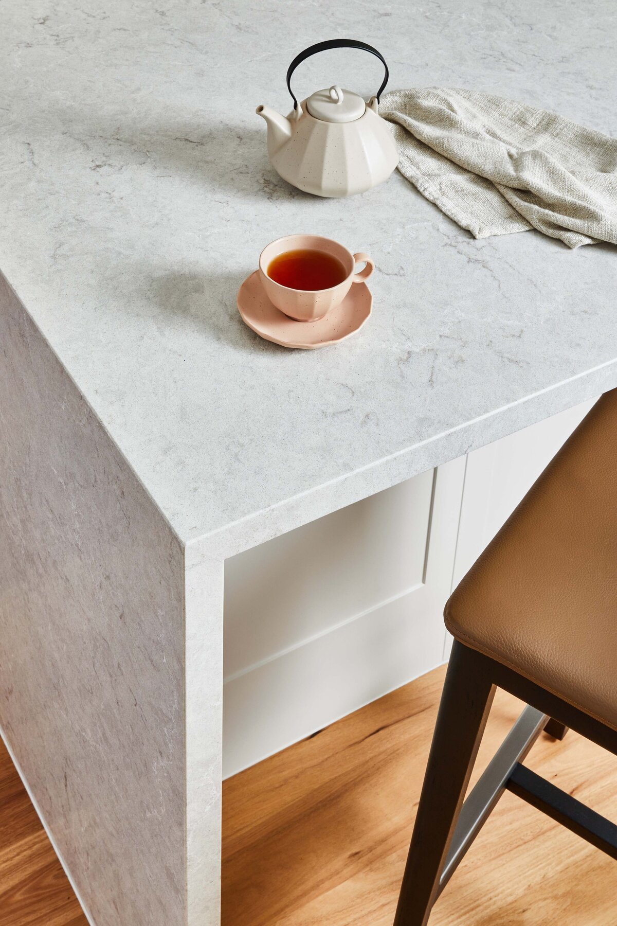 Detail of kitchen sink corner featuring white panelled cabinetry, ceramic planter, and natural light in a Williamstown Melbourne home.