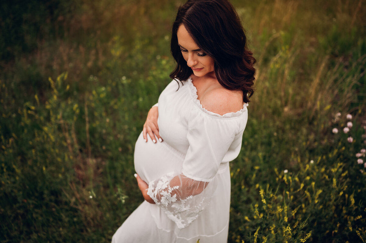 pregnant woman standing in wildflowers