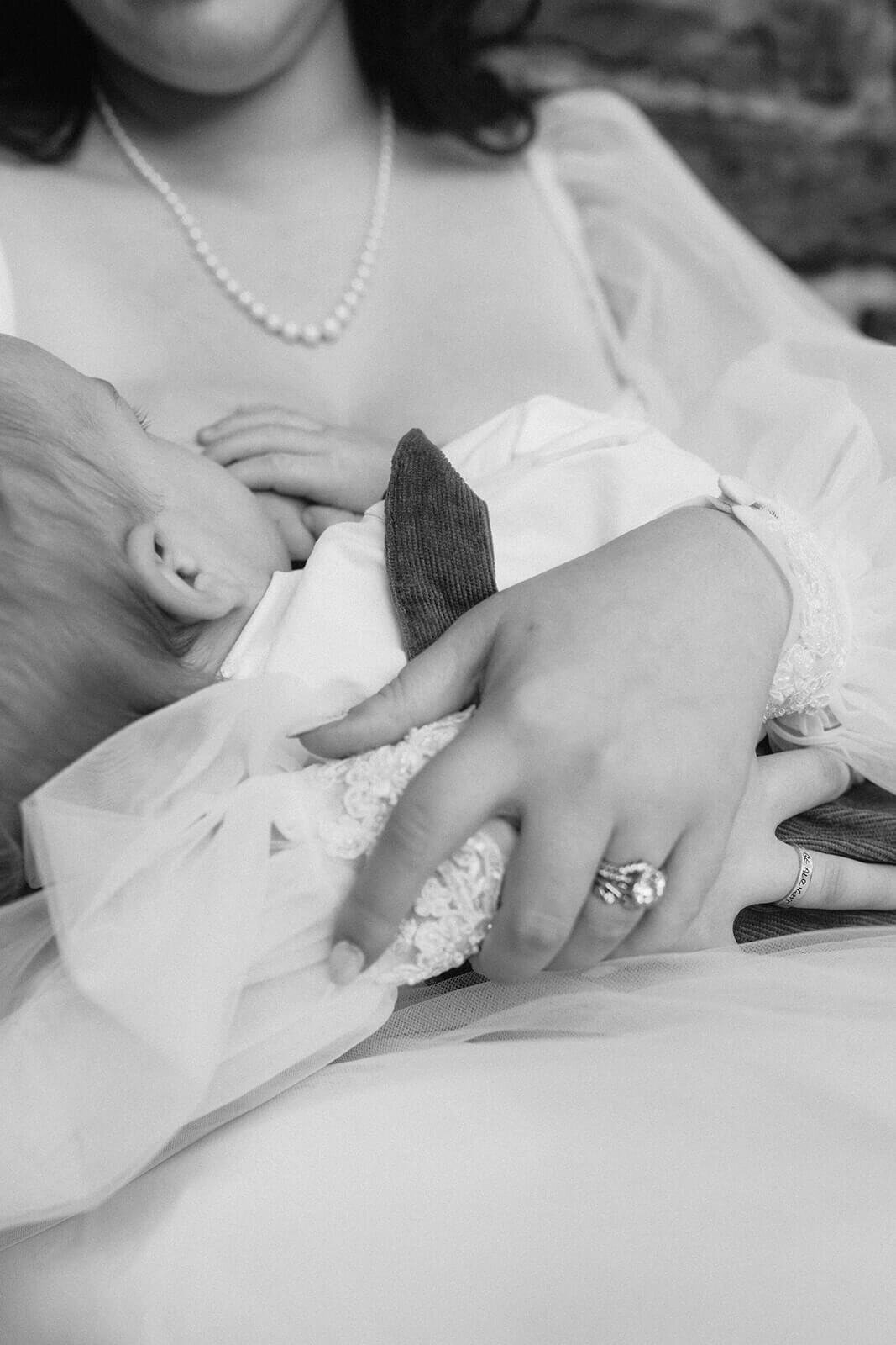 bride holding baby as he breastfeeds