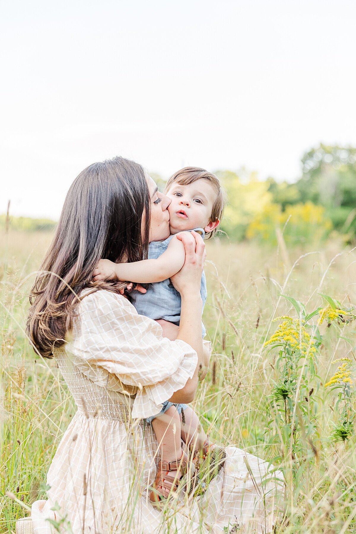mother kisses son during Family photo session with Sara Sniderman Photography at Heard Farm in Wayland Massachusetts