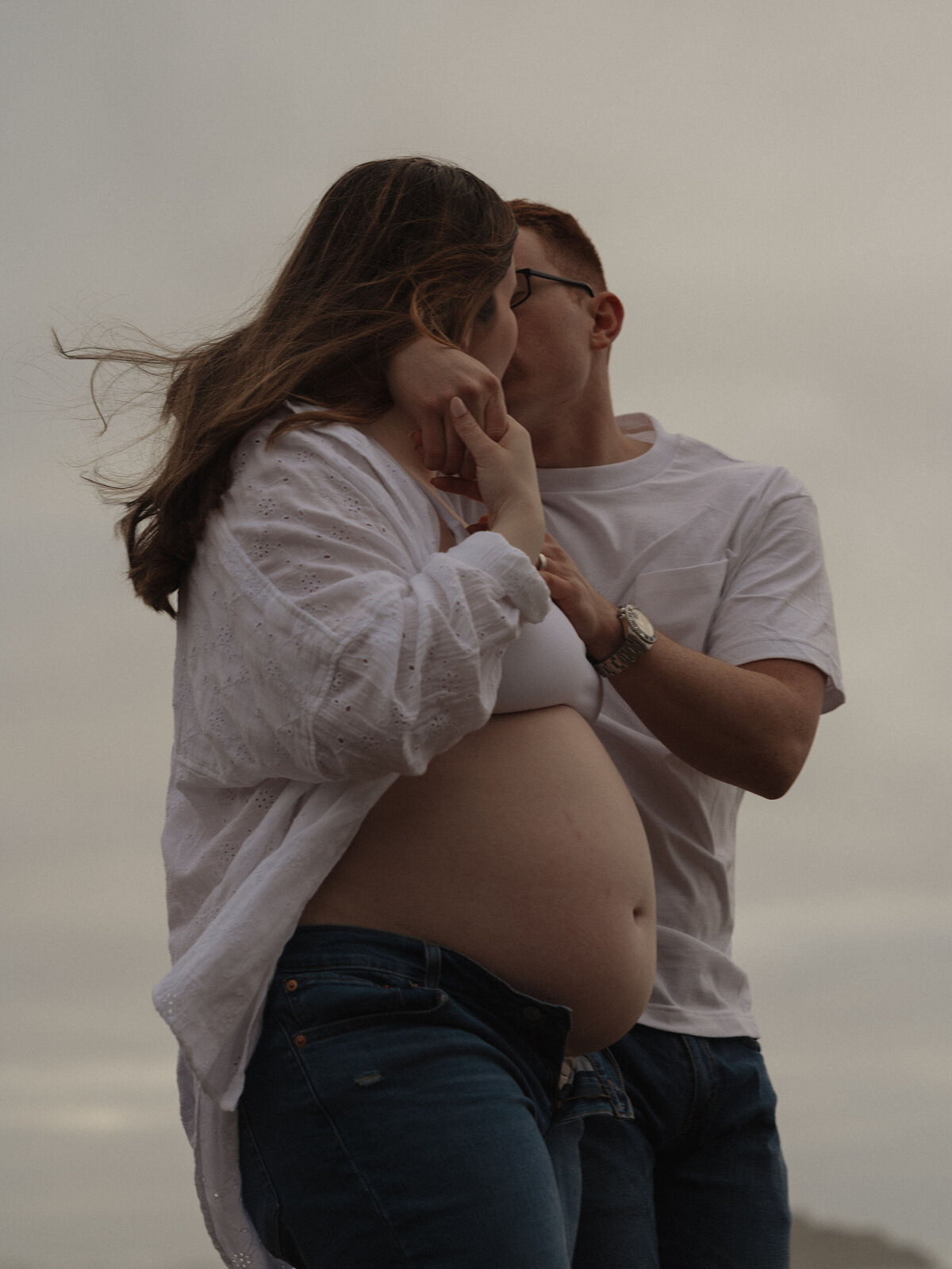 expecting parents enjoying the serene beach scenery together during a maternity session on the Oregon coast