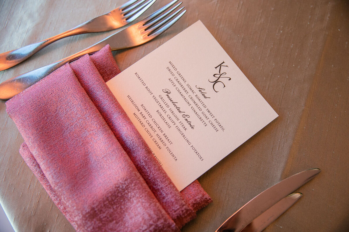 A pink napkin with a menu that says k & c on it