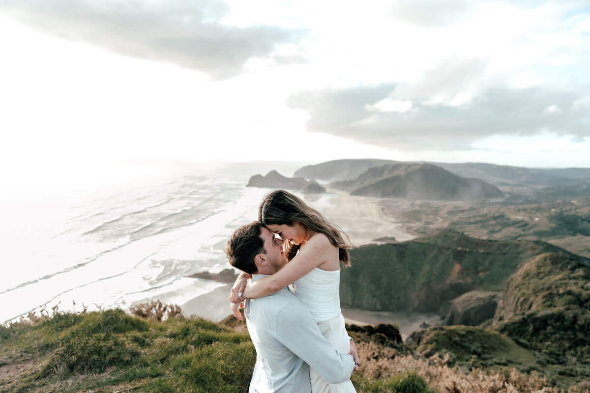 Romantic engagement photoshoot in Auckland with a couple standing beside a luxury helicopter, captured by Zanthe Vorsatz, wedding and proposal photographer.