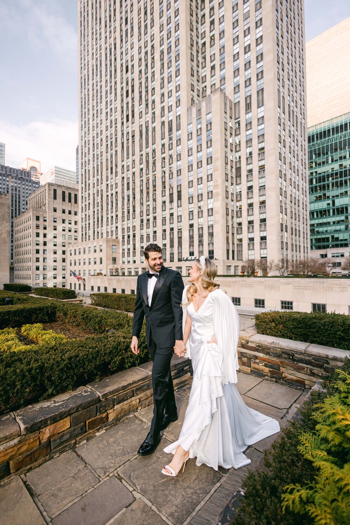 Bride and groom holding hands walking through 620 Loft and Gardens