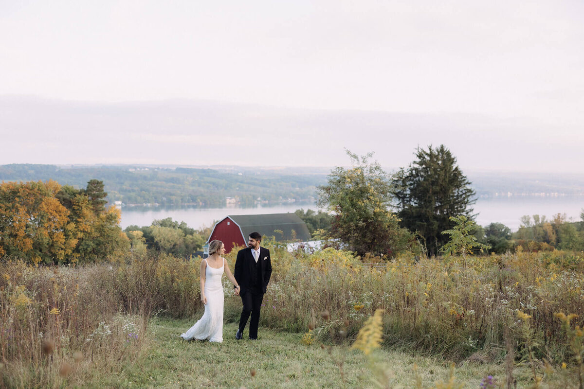 Bride and groom walking along grassy area at Finger Lakes Wedding, New York