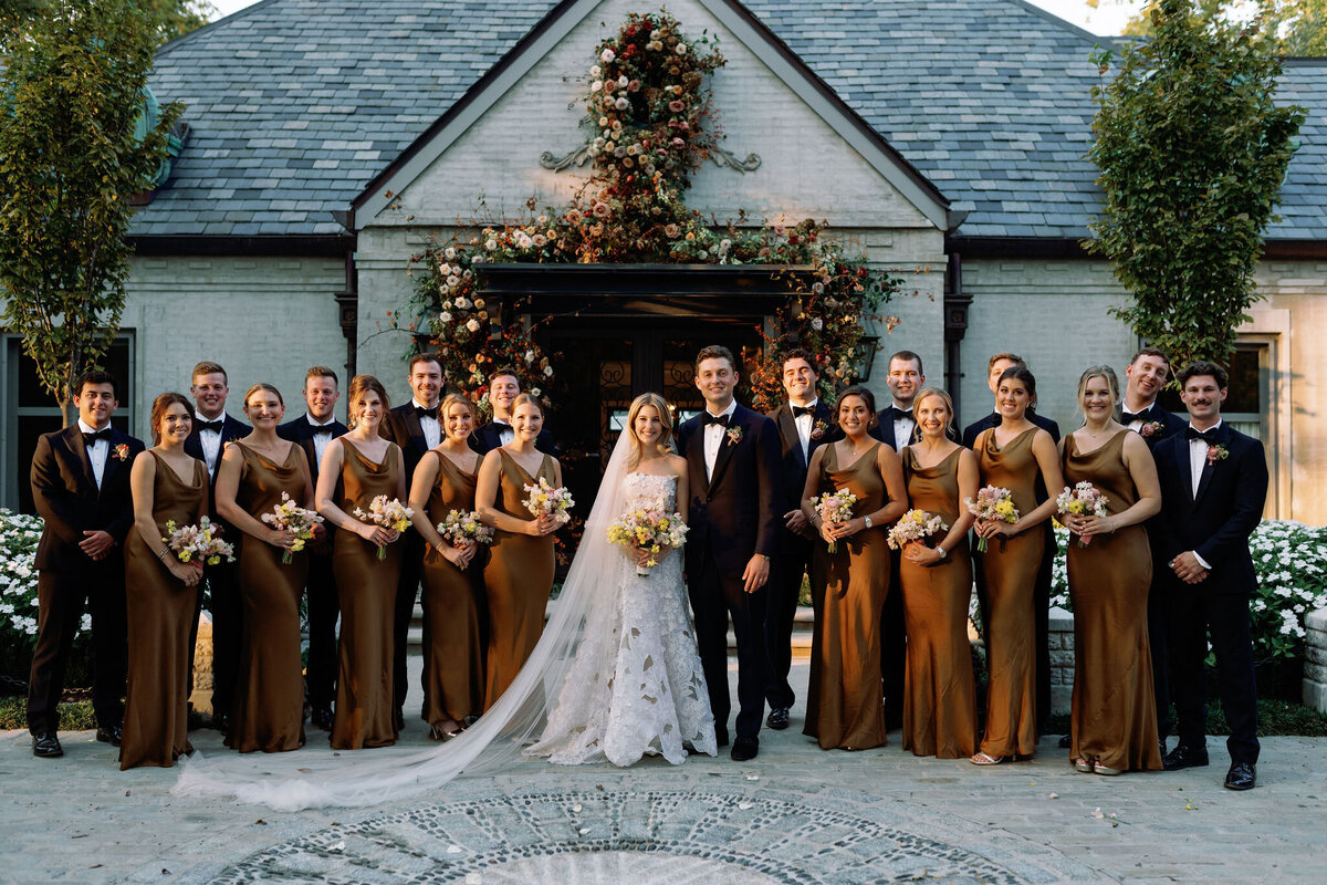 Organic growing floral installation for fall wedding ceremony backdrop. Private residence wedding build out for outdoor wedding ceremony and reception. Whimsical and organic floral design for autumnal wedding in colors of copper, yellow, blush, cream, and pops of orange. Clear tented wedding outside Nashville, TN. Design by Rosemary & Finch Floral Design in Nashville, TN.