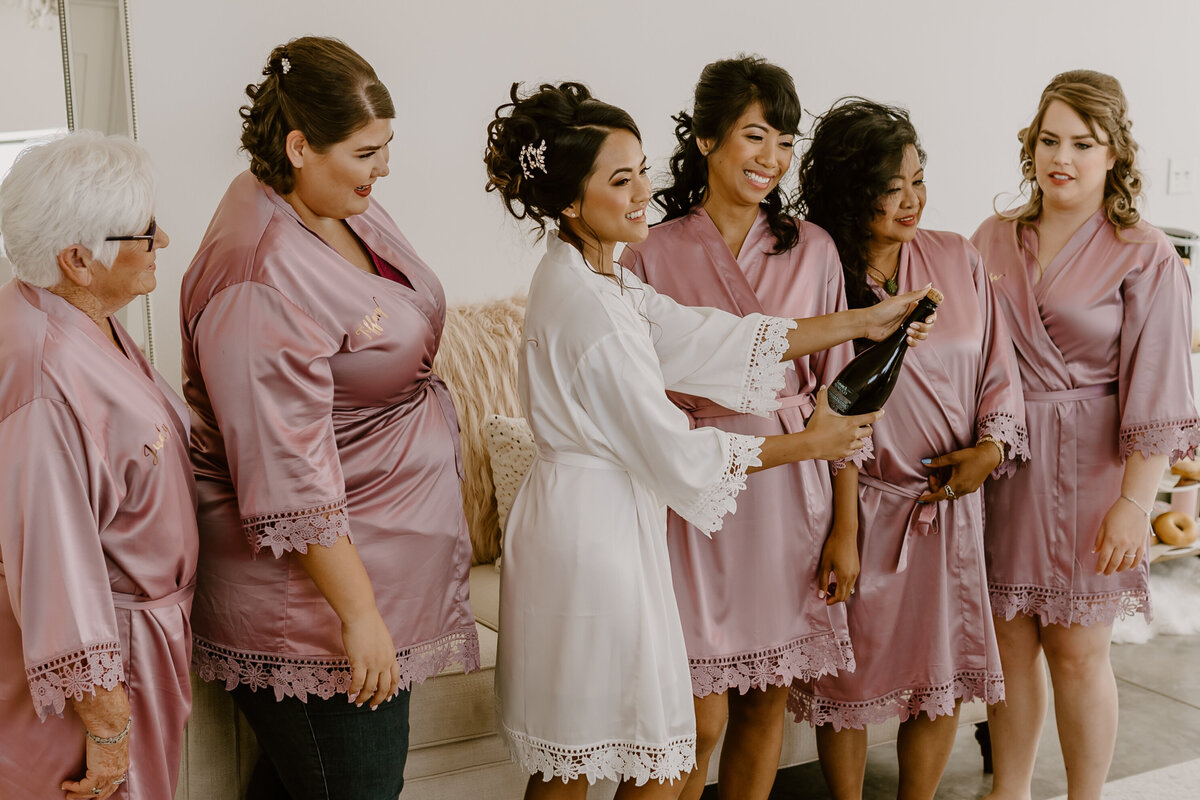 wedding-getting-ready-bridesmaids-champagne-pop-emerald-hills-events-promise-city-iowa-des-moines-wedding-photographer-storyteller-collective-photo-co