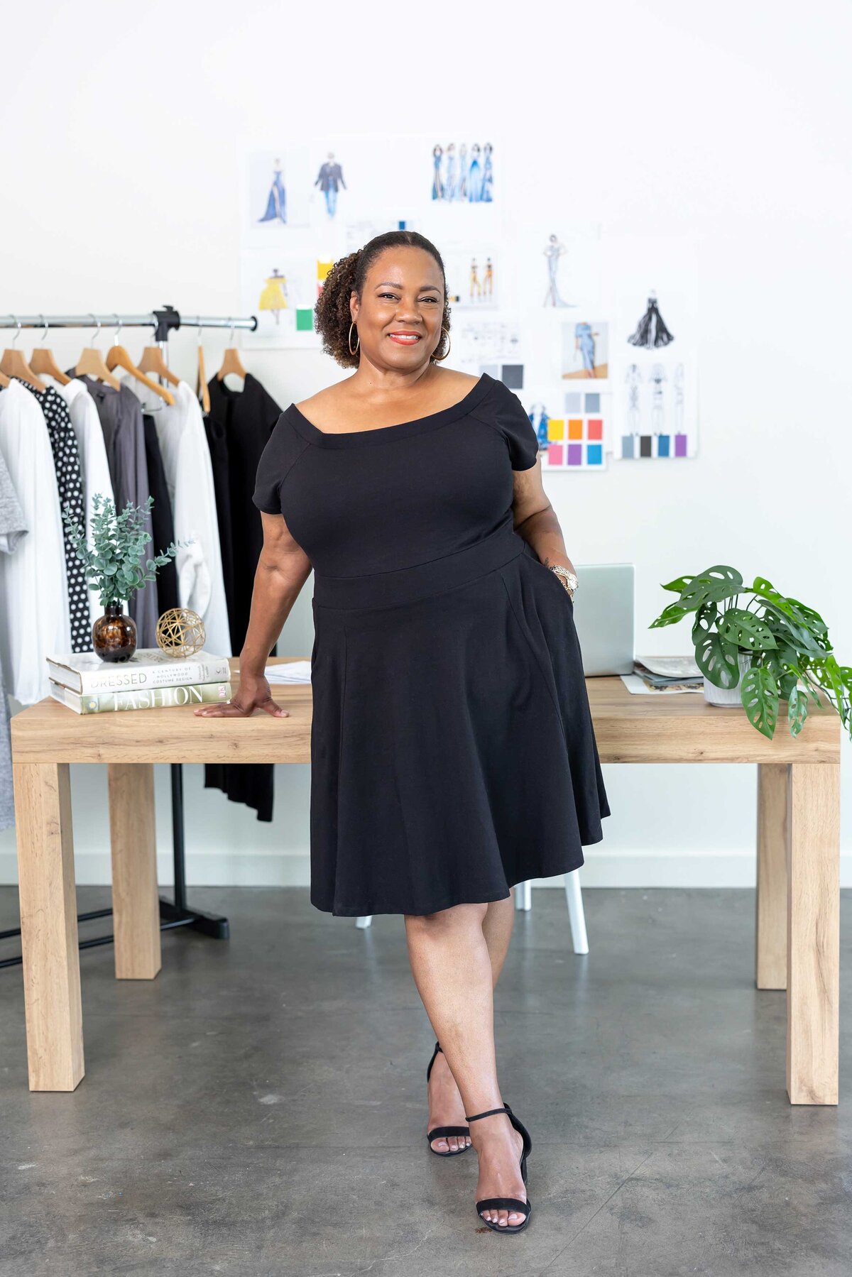 Content creation photography of a confident investor strategist in a sleek black dress, captured for a professional branding gallery.