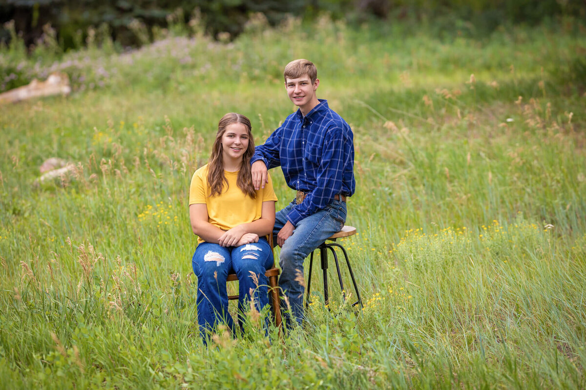 brother and sister sitting in a field together