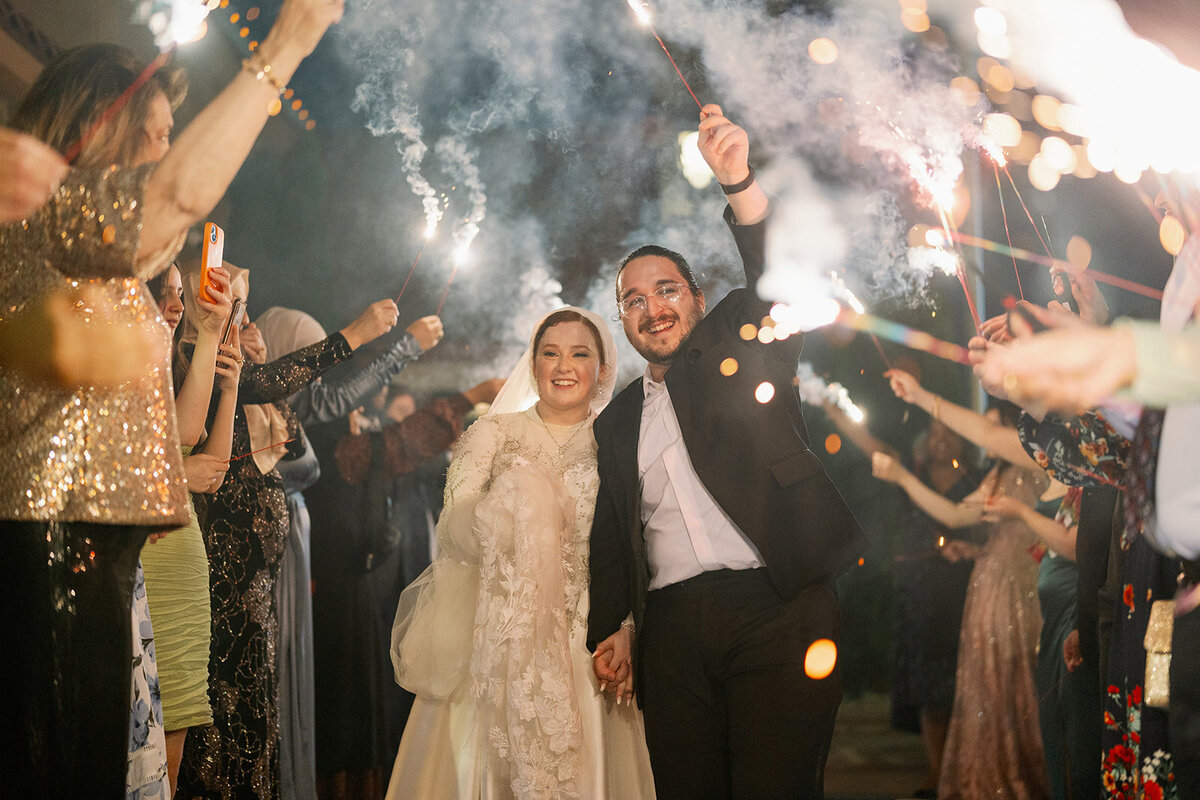 Newlyweds celebrating during a sparkler send-off at their Michigan wedding, photographed in Dearborn.