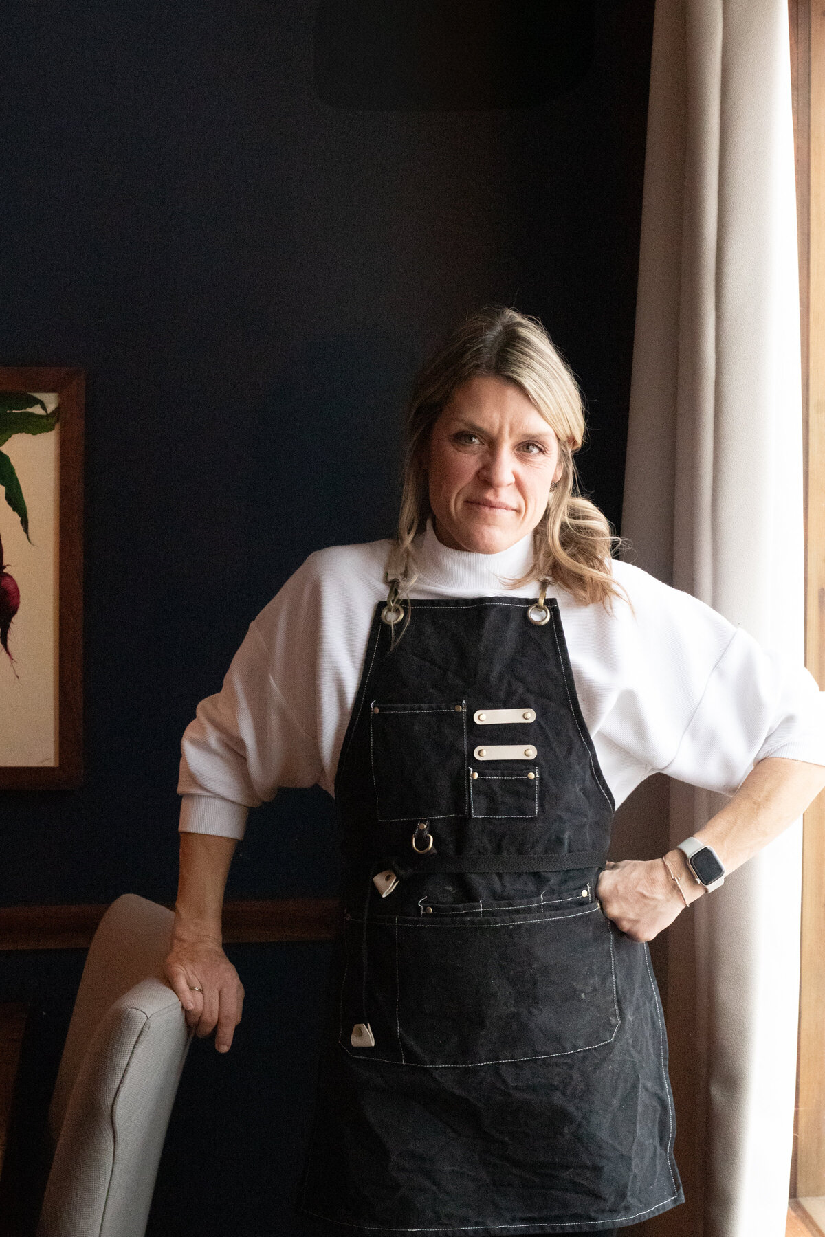 a woman smiling in a black apron