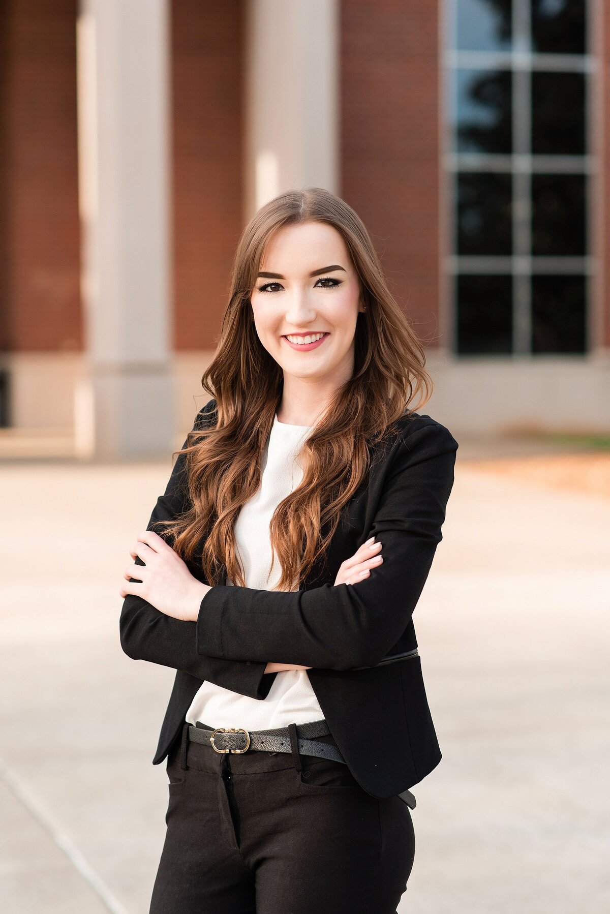 College Senior headshot for LinkedIn, wearing a black power suite with cream blouse in front of Middle Tennessee State University