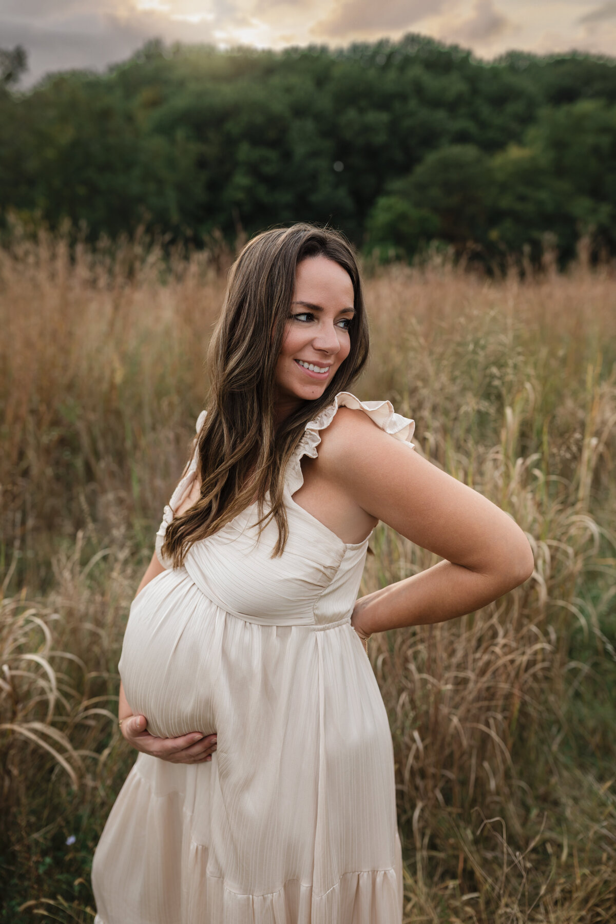 pregnant mother in pink silk maternity gown holding baby bump for maternity photoshoot cleveland maternity photographer