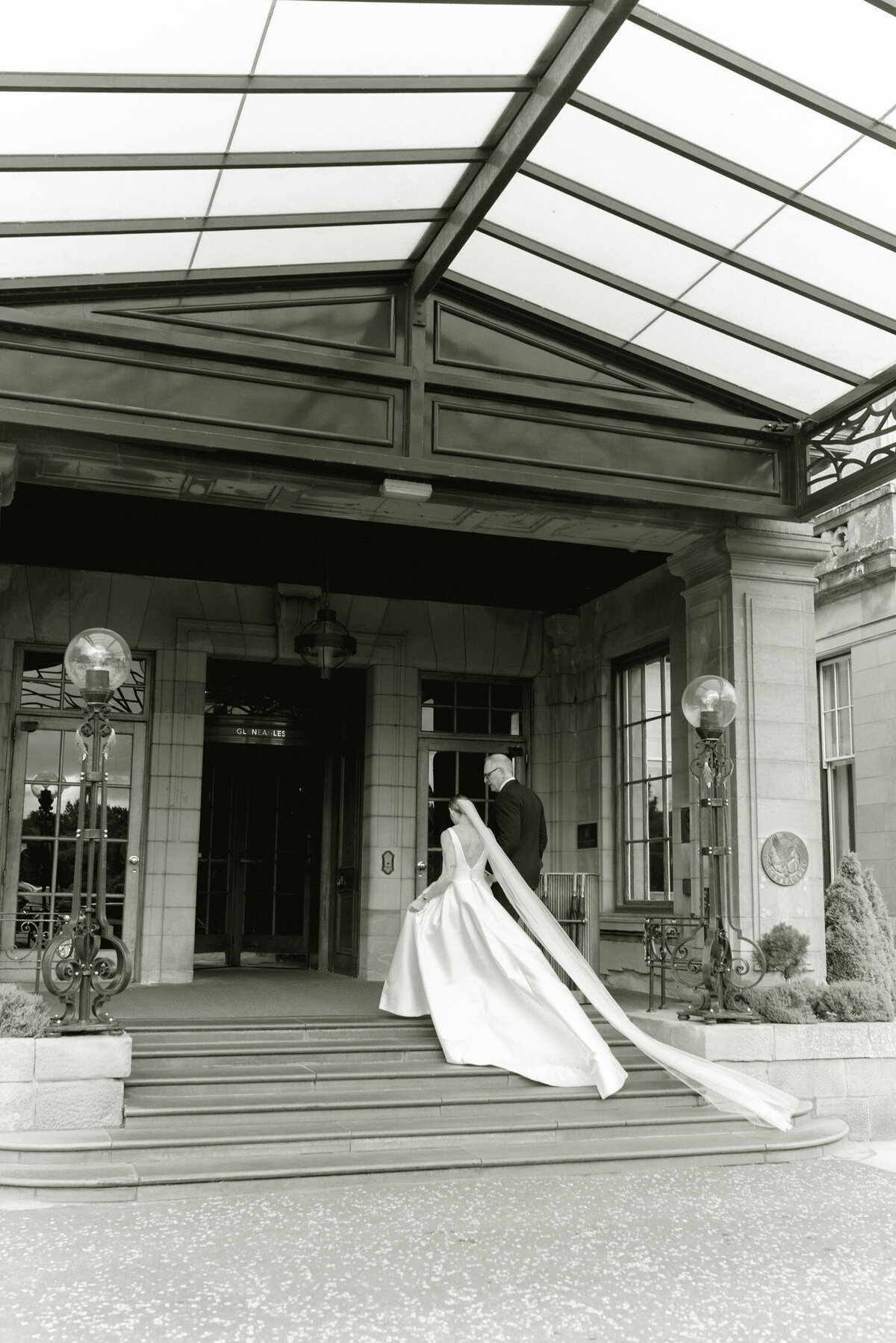 Editorial wedding photograph of Bride and Groom in front of Gleneagles hotel on their wedding day. Image by award winning wedding photographer Scotland, Jill Cherry Porter.