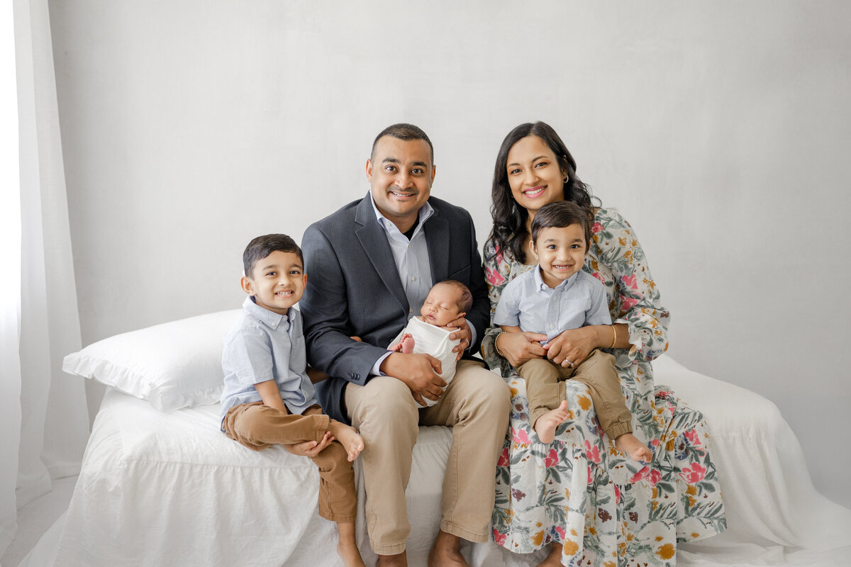 Elegant newborn family portrait in Tampa studio with parents holding baby boy in soft natural light