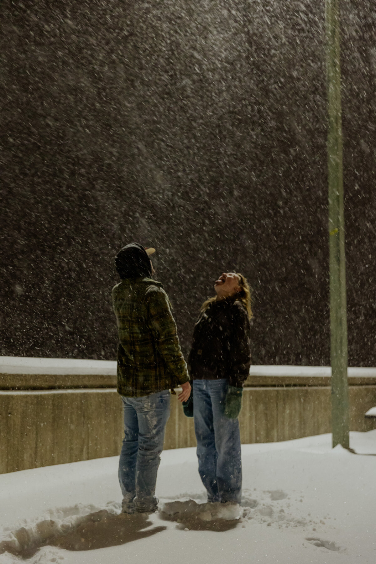 Couple Playing in the Snow and Catching Snow on their Tongues at Night 