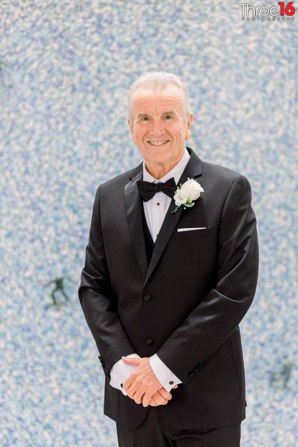 Groom poses with smile for the photographer
