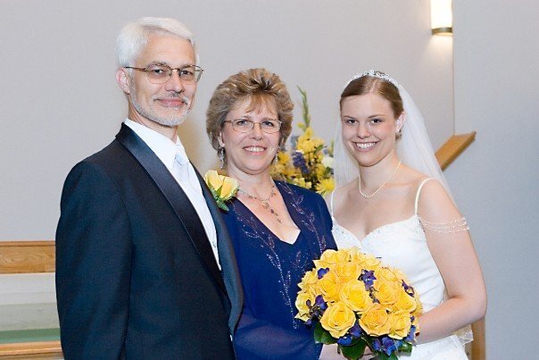A picture of me on my wedding day in the church with my mom and dad.